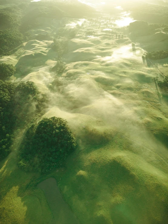 an aerial po of grassy hills and water