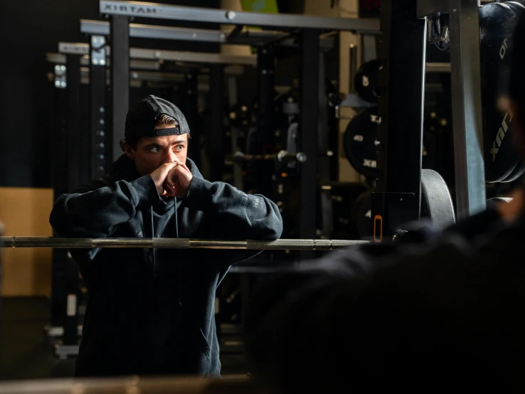 man wearing a cap is standing in the gym