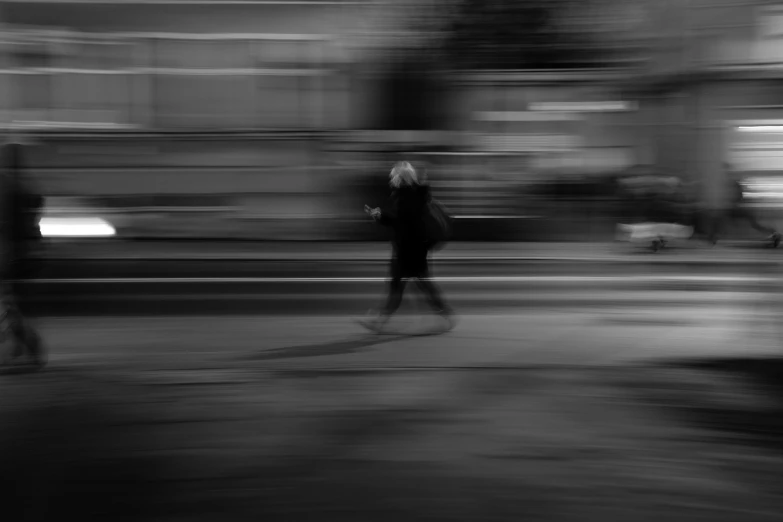 two people walking down the street in black and white