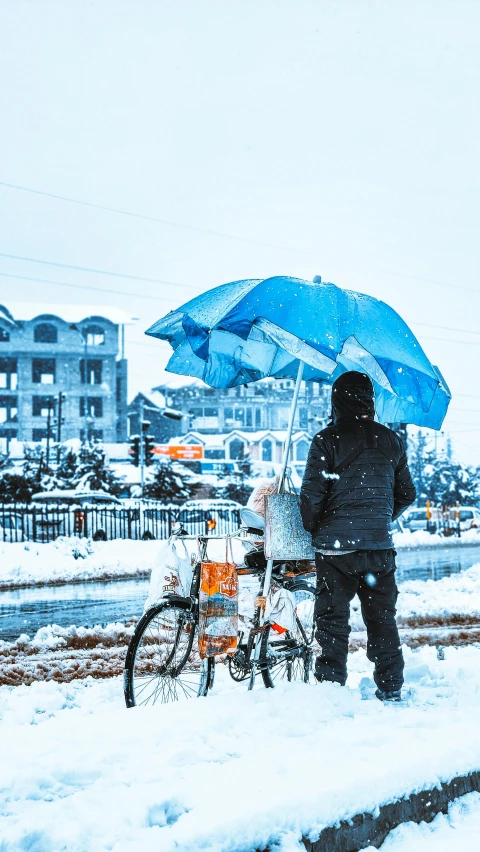 a man standing next to a bicycle holding an umbrella