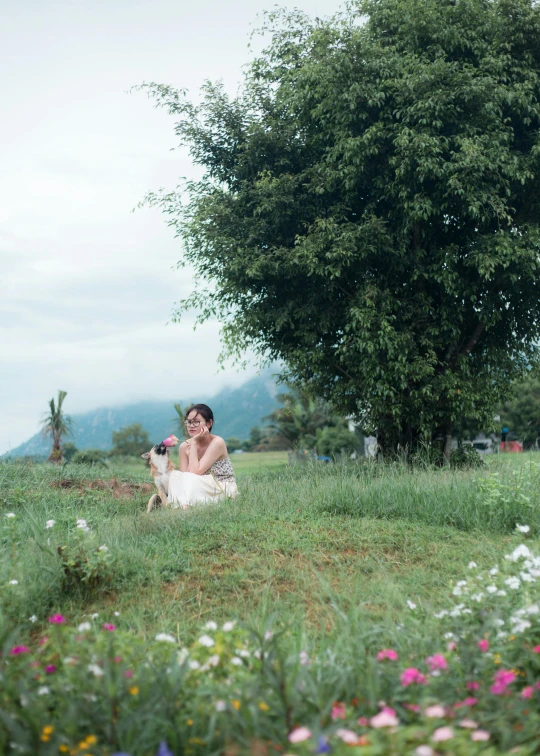 a woman kneeling in a field with her arm out