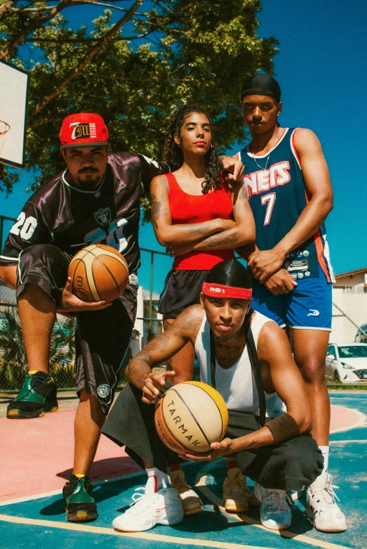 a group of people holding basketballs and posing for a po