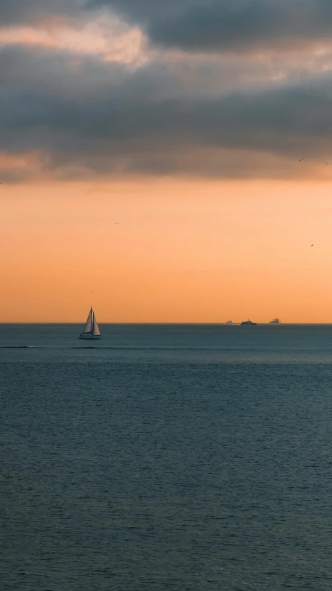 a sail boat floating in the middle of the ocean