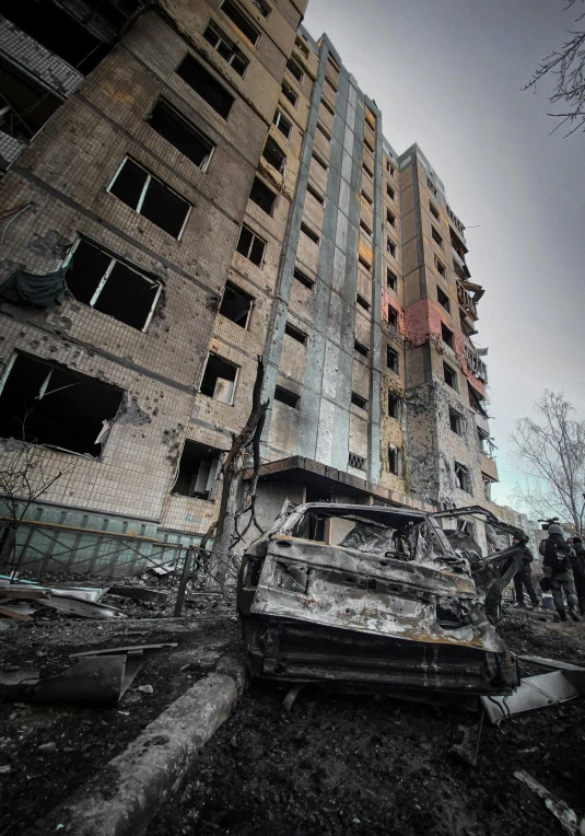 an old building with debris and a rusted out car