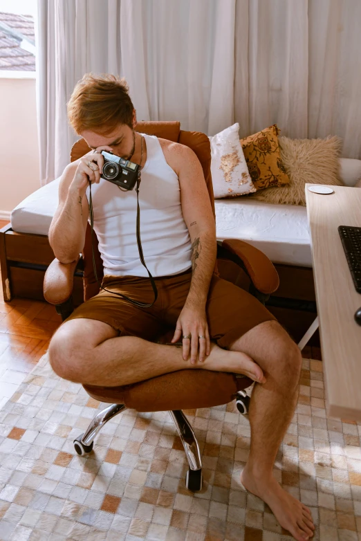 a person sitting on a chair holding a camera