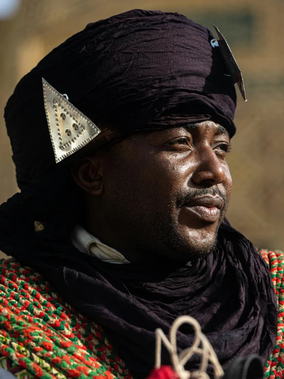 a man is dressed in a black hat and tie