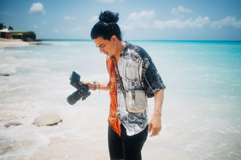 a young lady using a camera on the beach