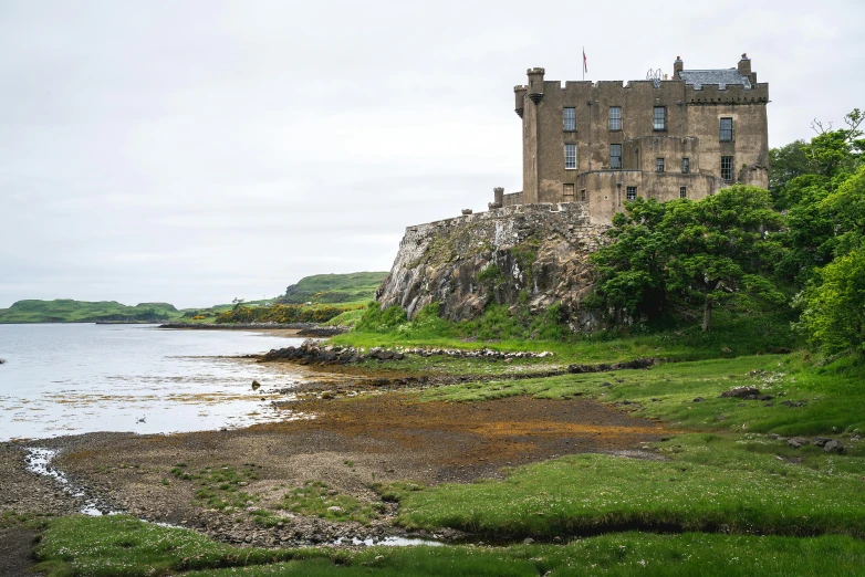 the grass is growing by the water by a castle