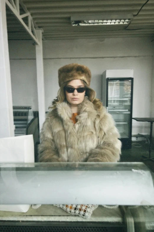 a woman wearing sunglasses and fur is posing for a picture