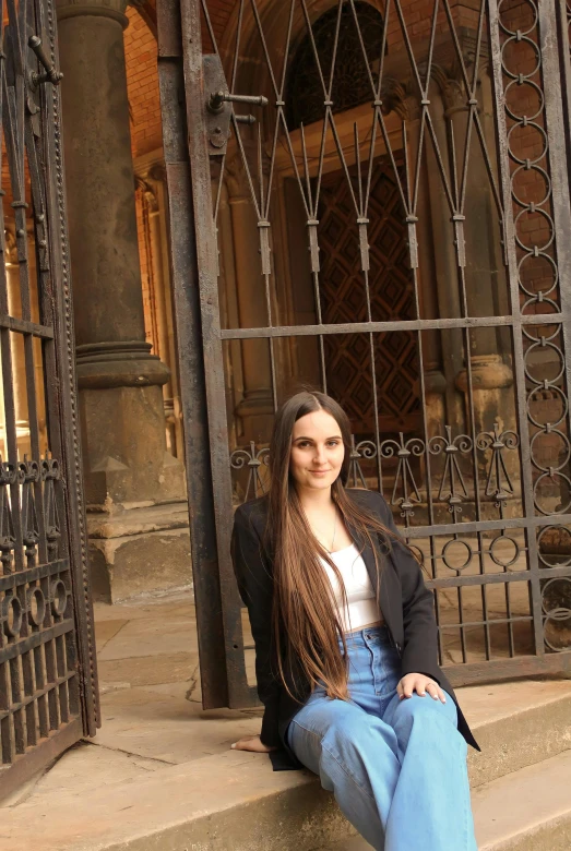 a woman sits on steps with her legs crossed