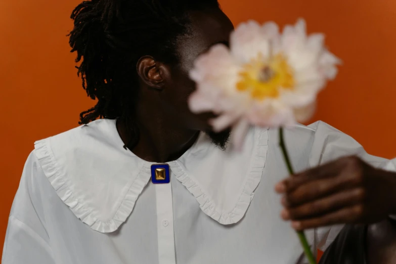 a woman holding a flower and smelling it