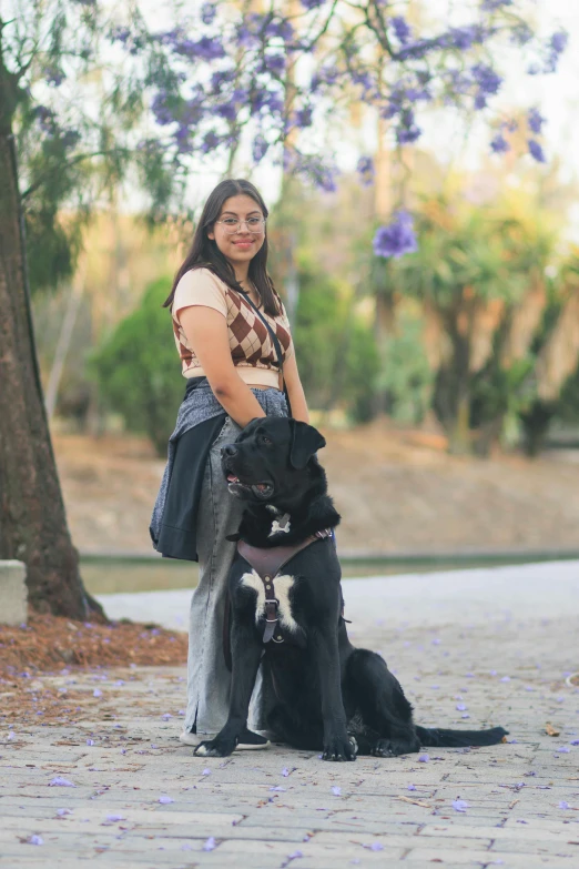 woman and dog smiling together with purple flowers in background