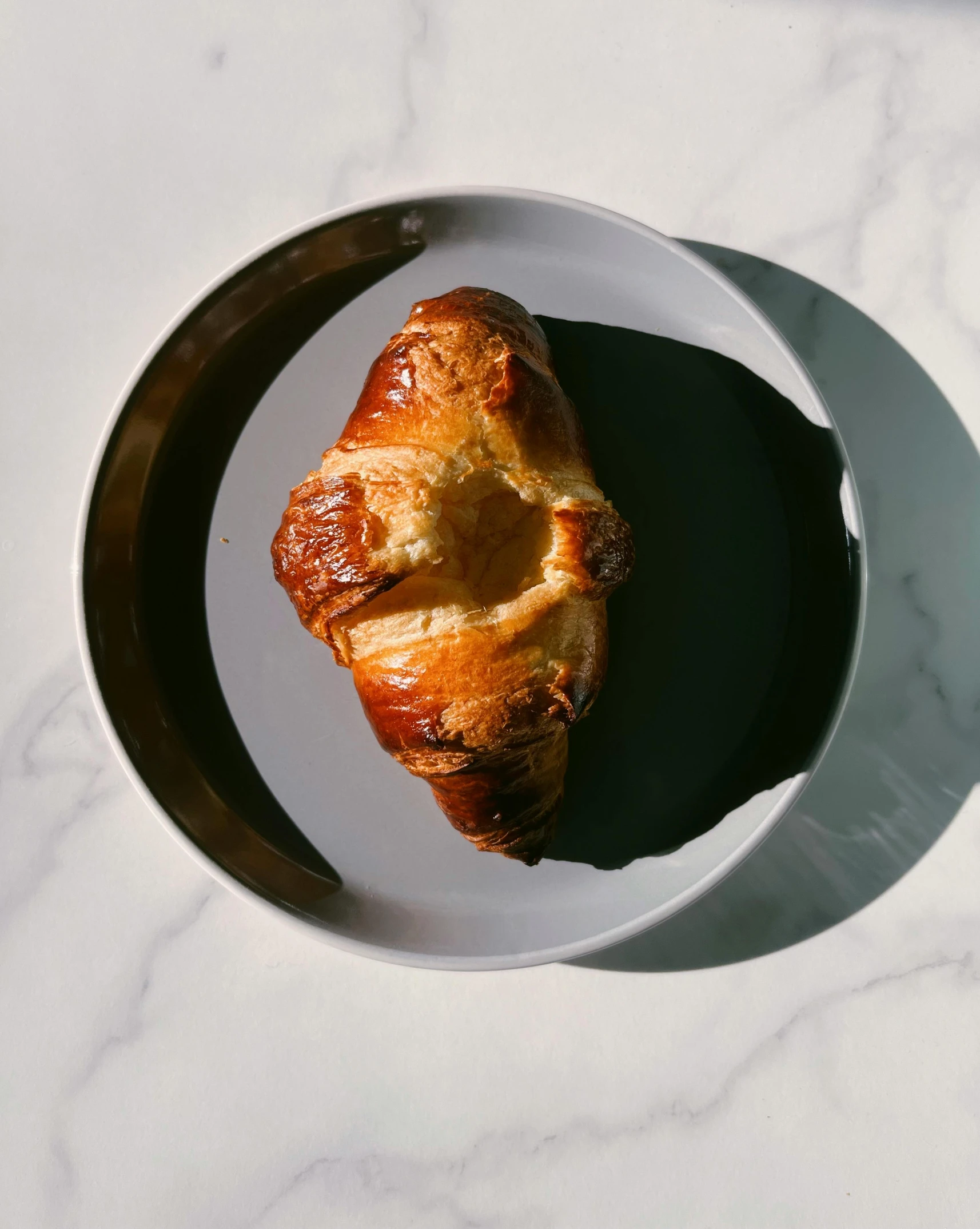 a croissant is placed on a plate ready to be eaten