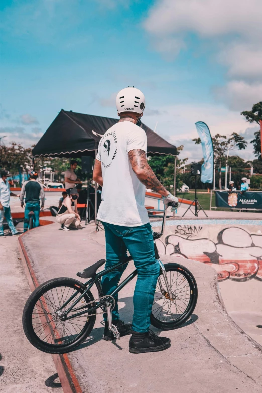 a man standing next to a bike and another person near by