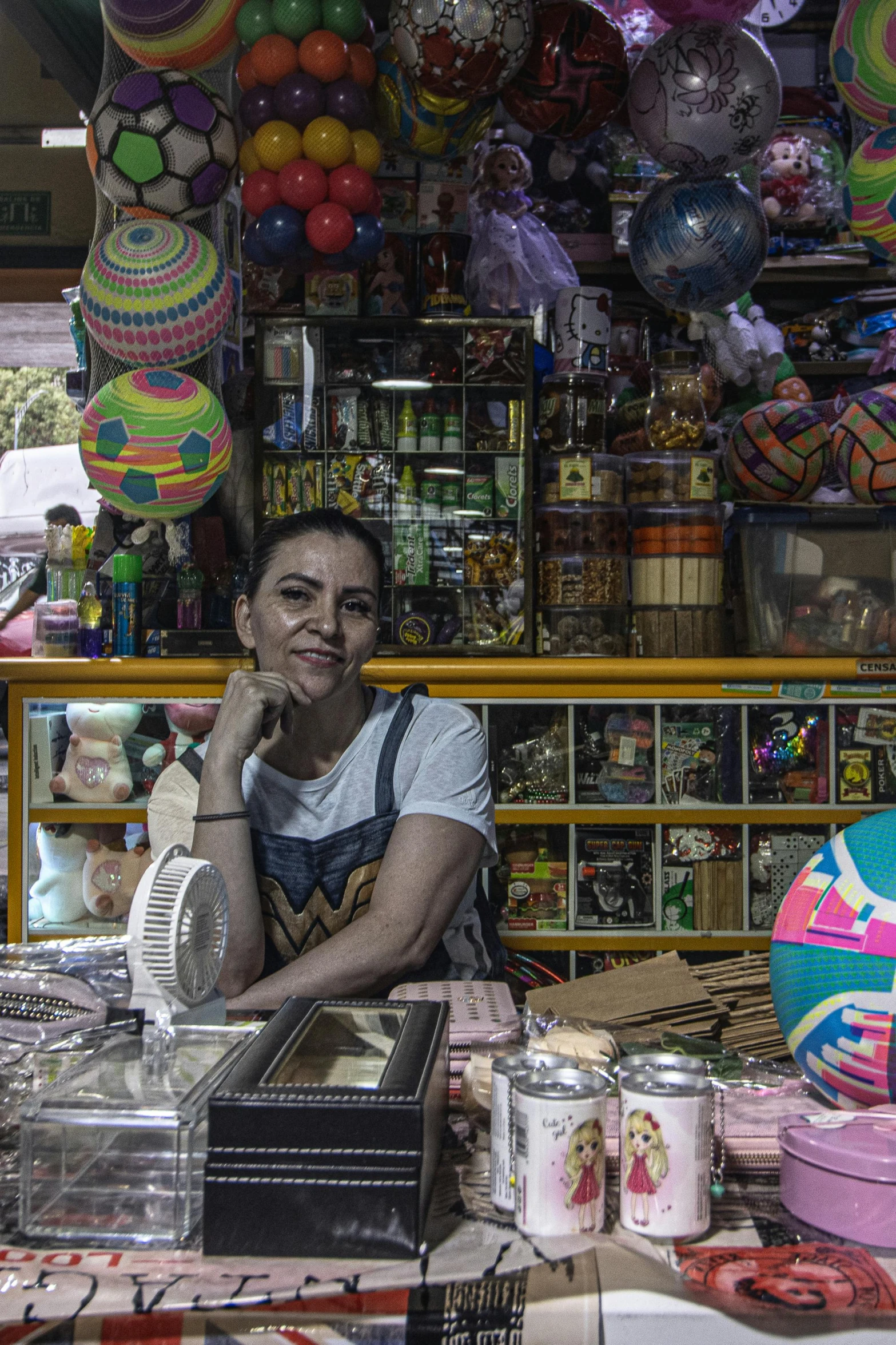 a man is sitting at a counter with some assorted balloons