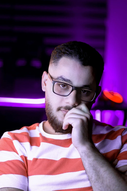 a man wearing glasses in front of a computer screen