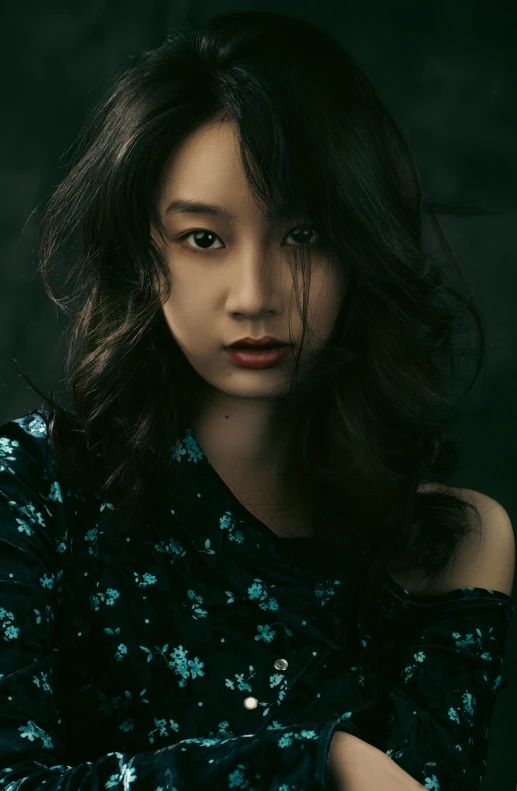 an asian woman poses for a portrait wearing blue dress