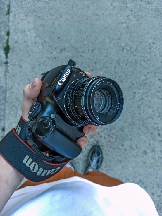 person taking a po with their camera in front of a wall