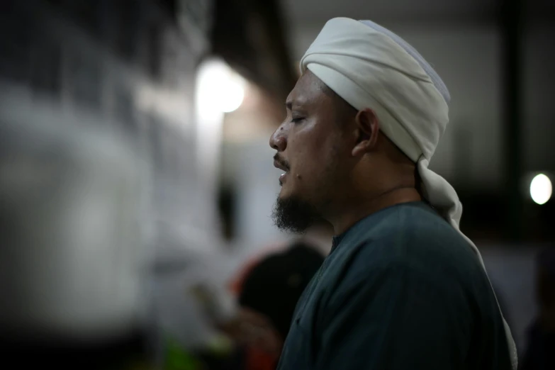 a man in a turban looks off into the distance