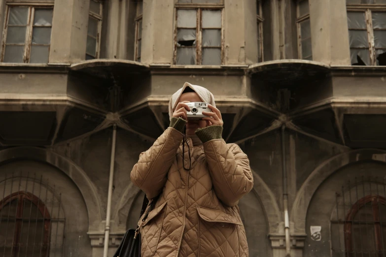 woman takes po on her digital camera outside a building