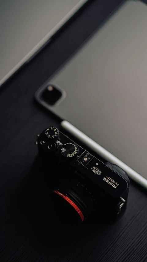 the phone is sitting on the table next to the camera