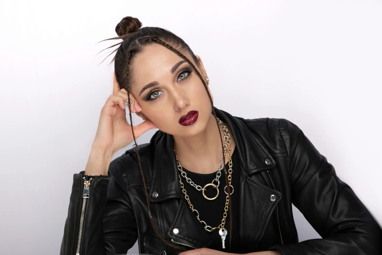 a woman with red lipstick and black leather jacket talking on a phone