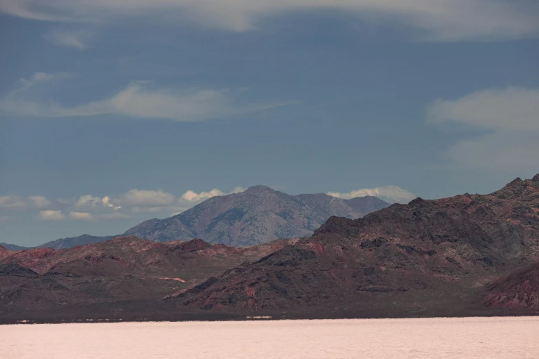 mountains surrounding a body of water with cloudy sky