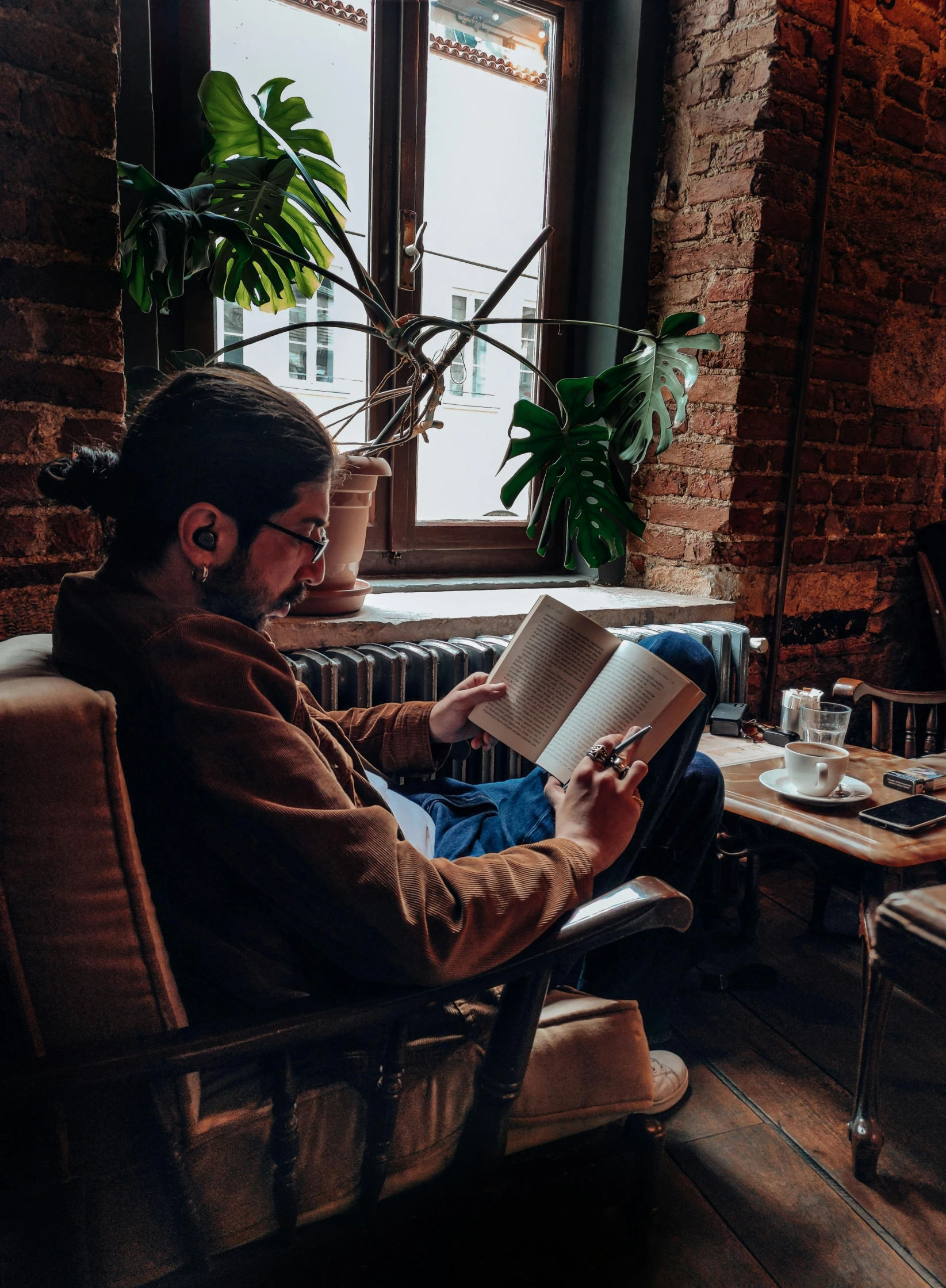 a man is sitting in a chair reading a book