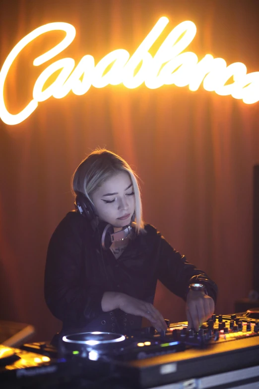 a young woman mixes music on the mixing board