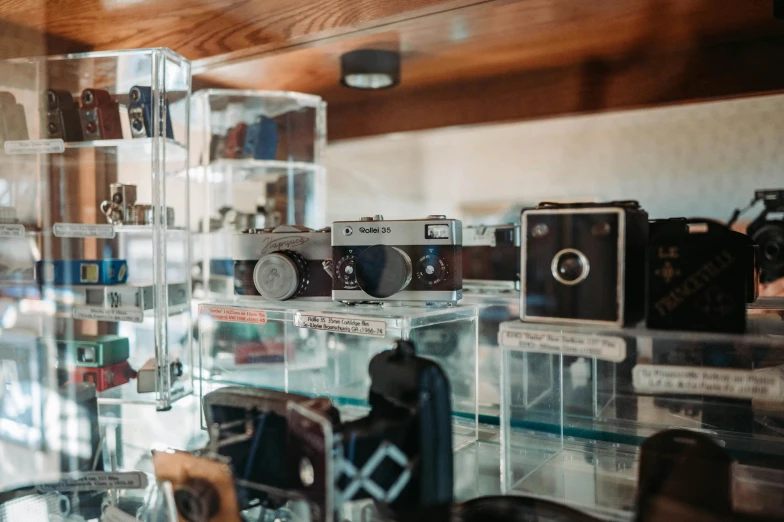 some glass cases filled with camera equipment and people