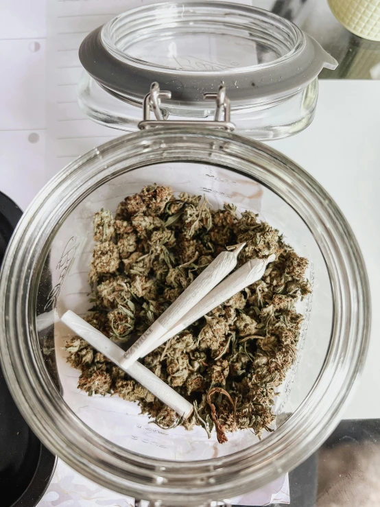 the top of a glass bowl with two smoking buds and one smoking cigarette