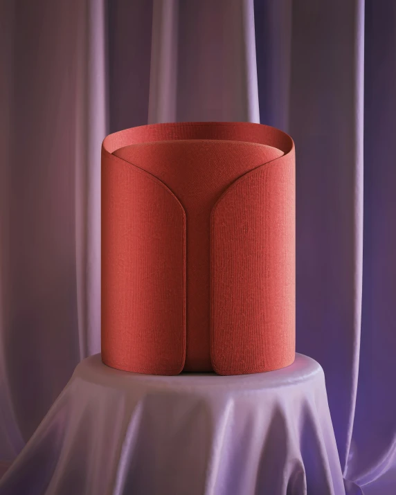 a red object on a table in front of some curtains