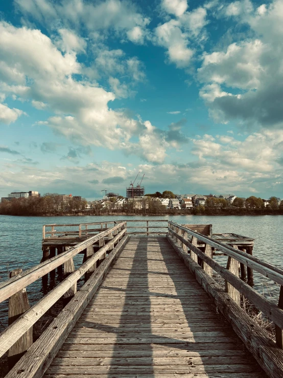 the shadow of a pier stretching over a body of water