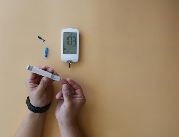 a person holds an electronic thermometer next to a pen