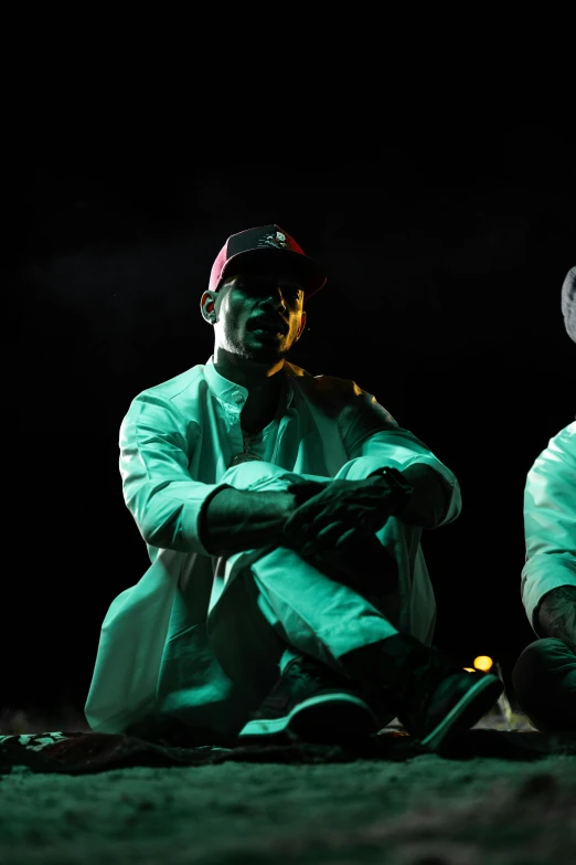 two people are sitting on the ground wearing white outfits