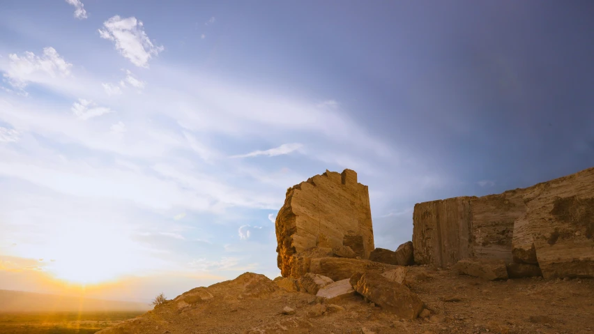 some rocks and a small tower and some grass