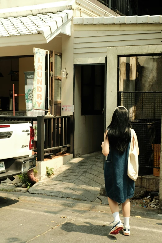 a lady with a white shirt walking toward a house