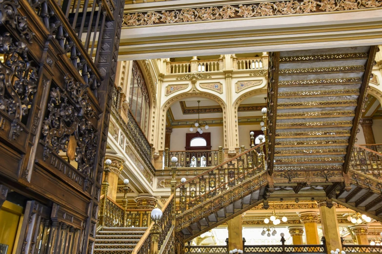 ornate stairways inside a large building with wood and metal accents