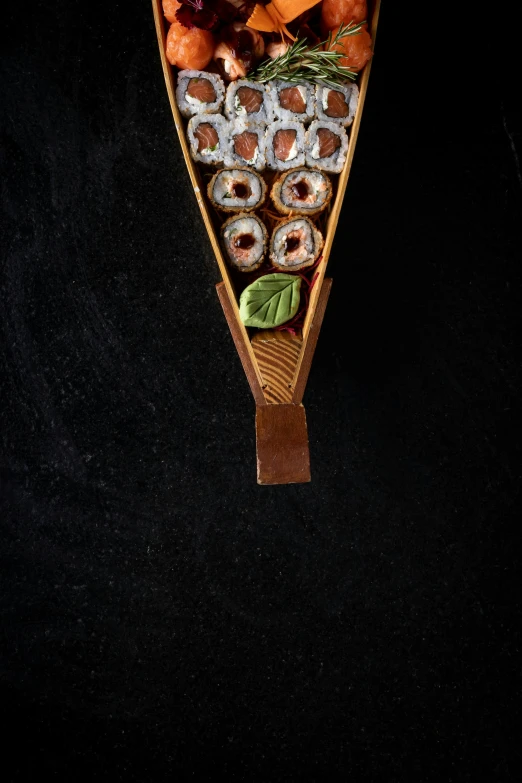 a wooden canoe holding donuts, carrots and other toppings