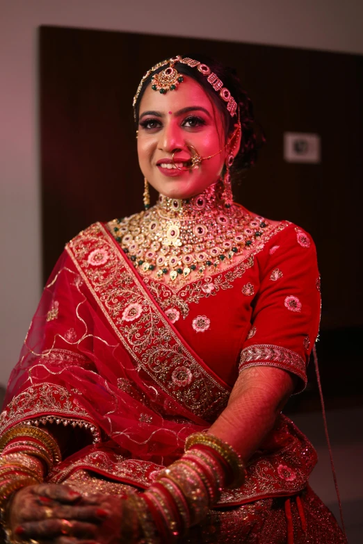 a beautiful indian woman wearing a bridal red outfit