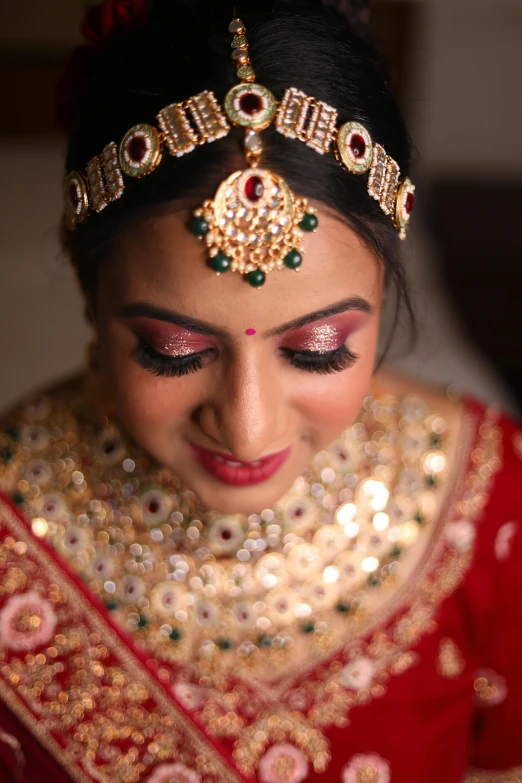 bride in a red outfit smiling with her jewelry on