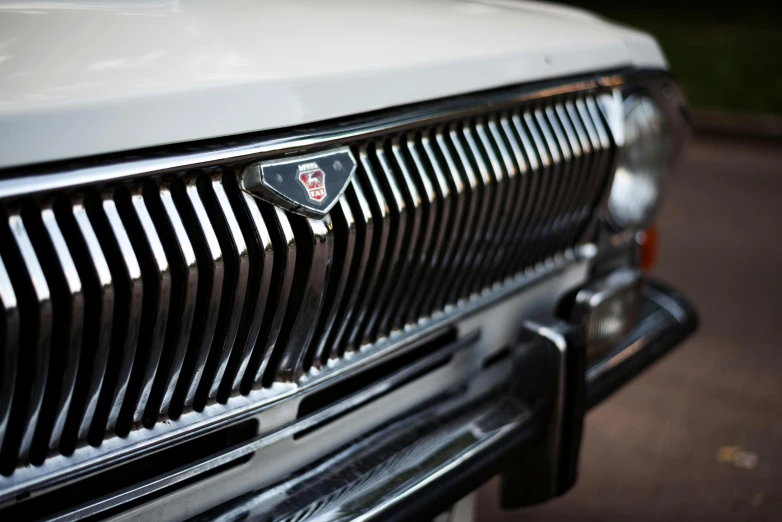 the front of a car with a badge and a grill design