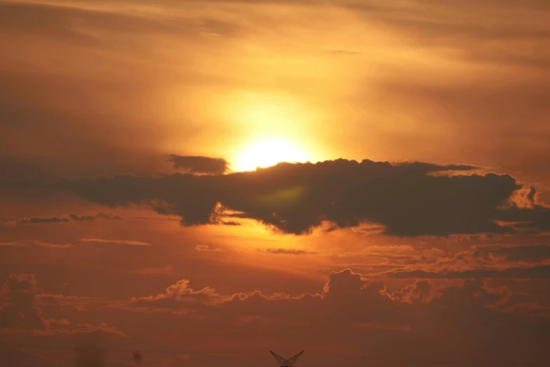 the sun is setting behind some clouds in a setting sky