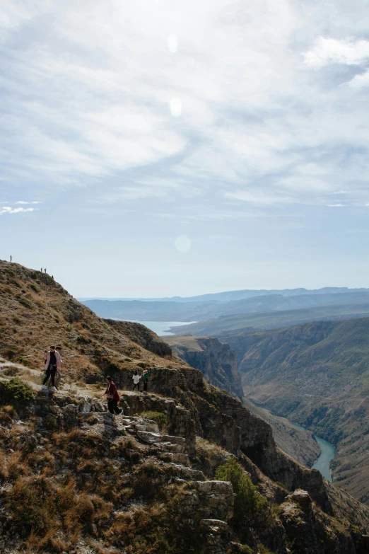 people on a mountain top overlooking a river