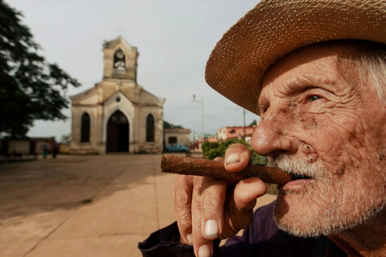 a man smoking a cigar in front of an old church