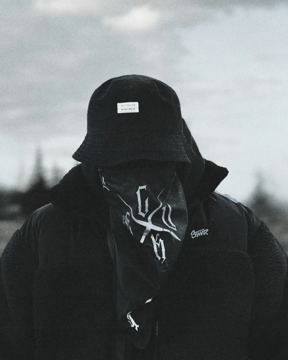 a man wearing a hooded jacket and scarf over his face