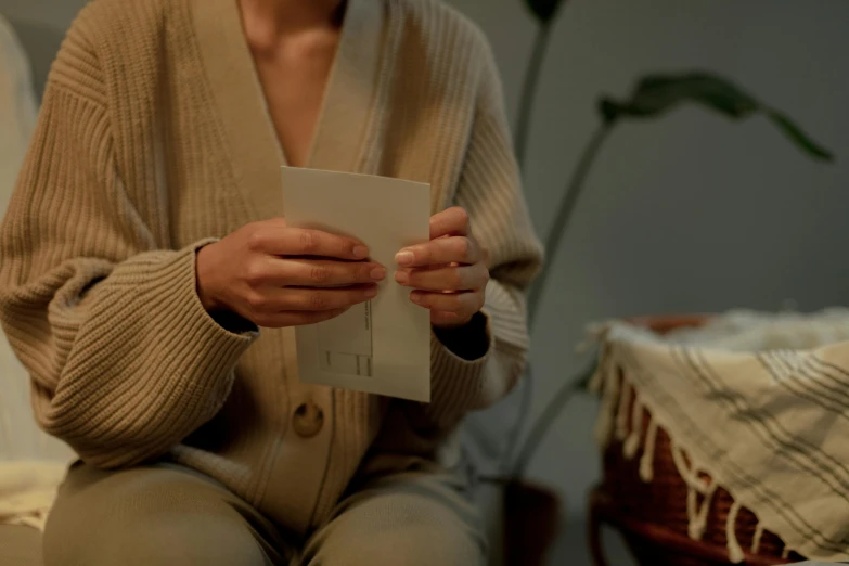 a woman is holding her credit card while sitting on the bed