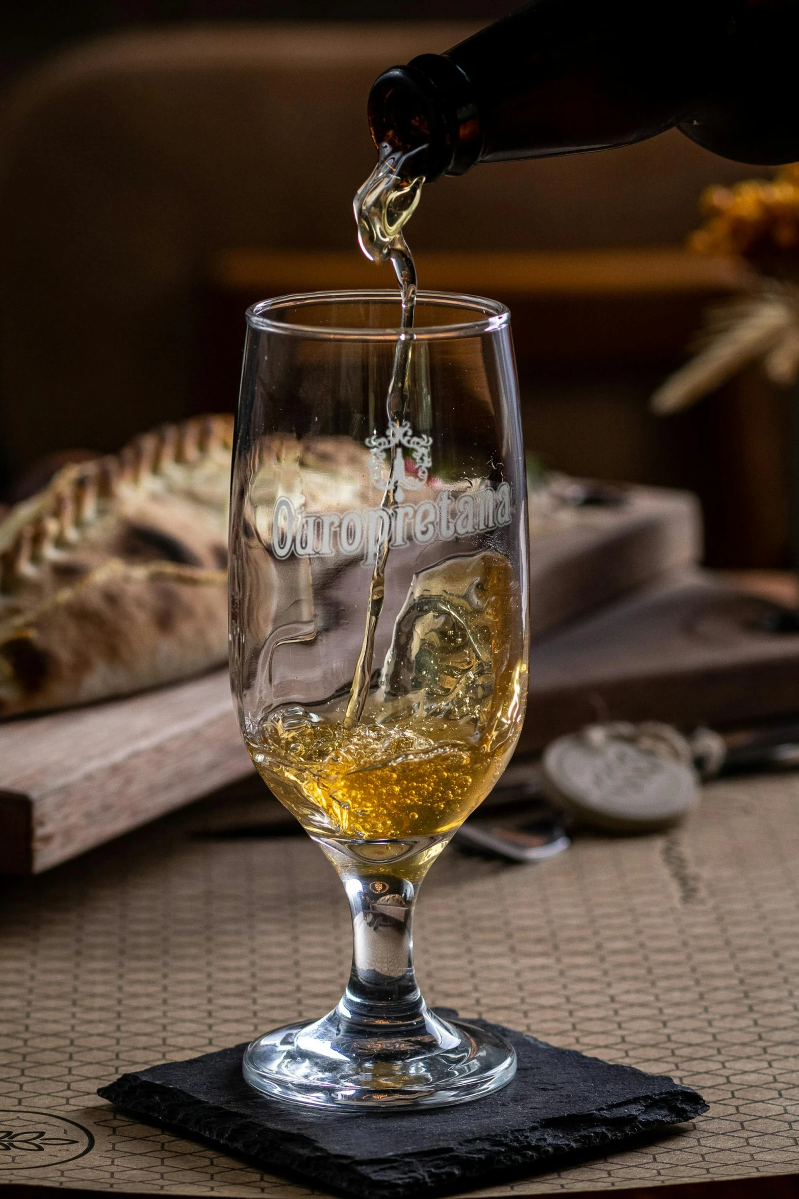 a glass filled with white wine on top of a table