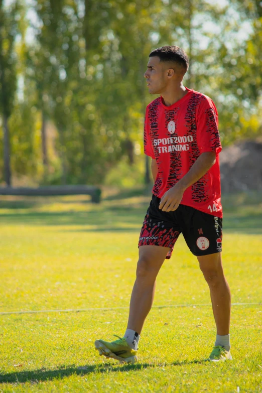 there is a young man playing soccer in the park