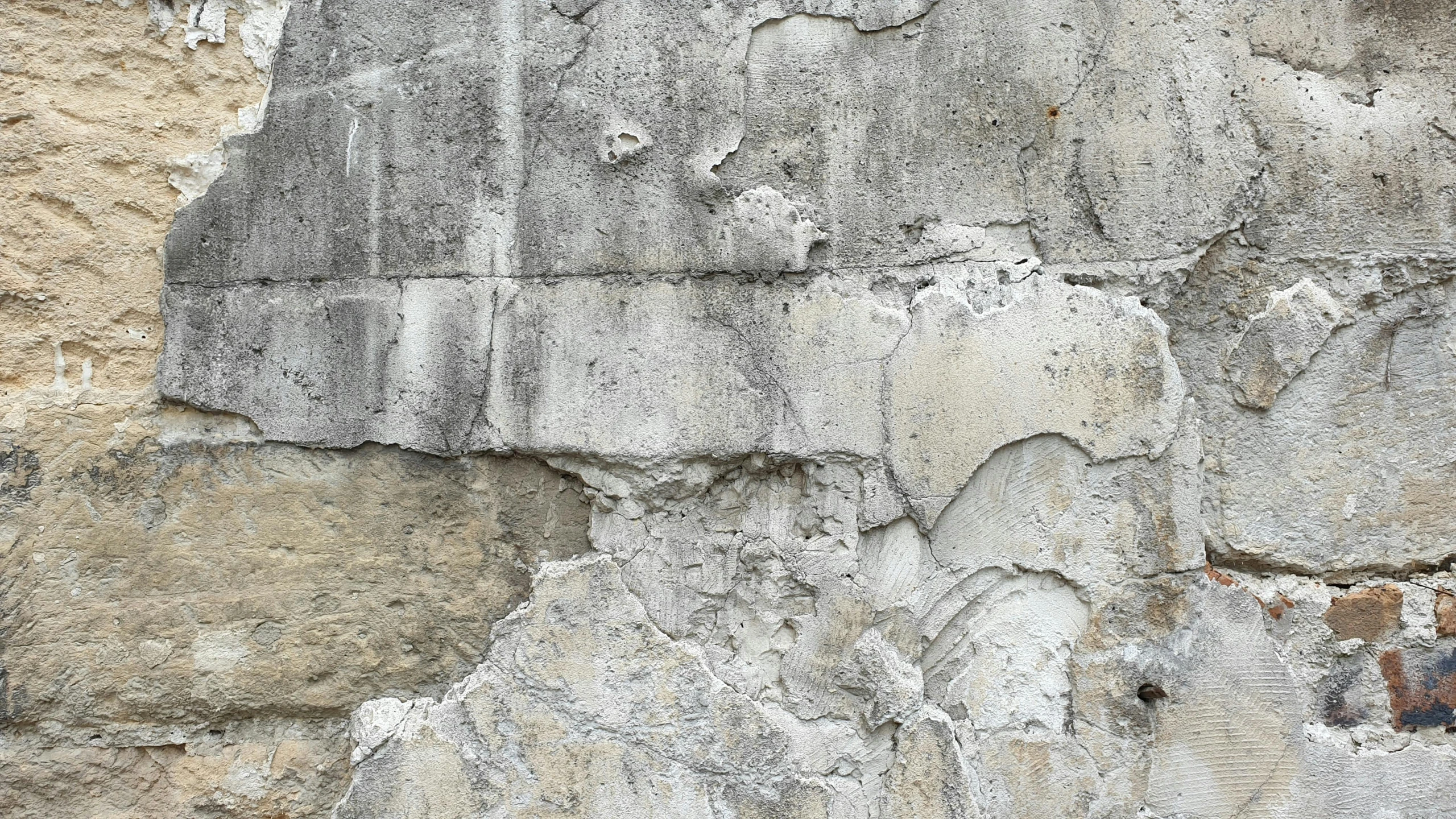 a gray stone wall with different colored markings